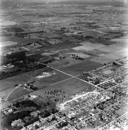 Looking west from Palace Road (Now Sir John A. Macdonald) with prison water tower, prison farm, Mowat Hospital and Portsmouth Ave. showing Traymore Ave. in bottom right to nearby Collins Bay Prison in West. - V25.6-1-9-5